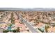 Expansive aerial view showcases a neighborhood with uniformly tiled roofs and palm trees, set against distant mountains at 7445 Shangri La Ave, Las Vegas, NV 89147