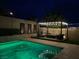 Backyard oasis featuring a well-lit seating area and privacy decor with a tranquil pool at 7569 Shadow Estates Way, Las Vegas, NV 89113
