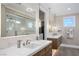 Well-lit bathroom featuring double sinks, modern fixtures, and a walk-in shower and closet at 7569 Shadow Estates Way, Las Vegas, NV 89113