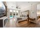 Spacious bedroom with a king bed, modern furniture, hardwood floors, and access to the backyard pool at 7569 Shadow Estates Way, Las Vegas, NV 89113