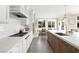 Bright kitchen featuring hardwood floors, white cabinets, and a stylish center island at 7569 Shadow Estates Way, Las Vegas, NV 89113