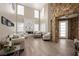 Elegant living room showcasing a stone accent wall, fireplace, and natural light through large windows at 7569 Shadow Estates Way, Las Vegas, NV 89113