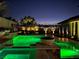 Beautifully landscaped backyard with pool featuring lighting and a covered patio at 7569 Shadow Estates Way, Las Vegas, NV 89113