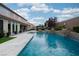 Backyard pool and patio area with lush landscaping and outdoor seating at 7569 Shadow Estates Way, Las Vegas, NV 89113