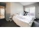 Bedroom features an exercise machine on the balcony, a comfortable bed and neutral colors at 7704 Himalayas Ave # 204, Las Vegas, NV 89128