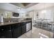 Kitchen with stainless steel appliances and black cabinets with a view of the dining space at 7704 Himalayas Ave # 204, Las Vegas, NV 89128