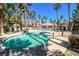 A beautiful swimming pool sits in front of an apartment building surrounded by tall palm trees on a sunny day at 7704 Himalayas Ave # 204, Las Vegas, NV 89128