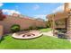 Backyard features artificial grass, a fire pit, and a covered patio at 7761 Boyd Ave, Las Vegas, NV 89179