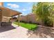 Backyard featuring artificial grass, a covered patio, and desert landscaping at 7761 Boyd Ave, Las Vegas, NV 89179