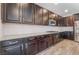 Modern kitchen features dark cabinetry, granite countertops, stainless steel appliances, and wood-look tile flooring at 7761 Boyd Ave, Las Vegas, NV 89179