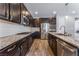 This kitchen boasts dark wood cabinets, stainless steel appliances, granite countertops, and a stylish tile backsplash at 7761 Boyd Ave, Las Vegas, NV 89179