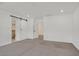 A spacious bedroom featuring a sliding barn door and neutral carpet at 8043 Texas Hills St, Las Vegas, NV 89113