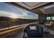 Relaxing covered balcony boasts comfortable seating and captivating mountain views at sunset at 811 Magnum Cliff Ct, Henderson, NV 89012