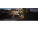 The lighted driveway of this modern home gives way to desert landscaping, creating a warm inviting vista at 811 Magnum Cliff Ct, Henderson, NV 89012
