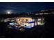 Modern luxury home at night featuring swimming pool, spa, outdoor entertainment and city views at 811 Magnum Cliff Ct, Henderson, NV 89012