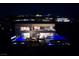 Modern home exterior at night featuring a pool, spa, and outdoor lounge area with city views at 811 Magnum Cliff Ct, Henderson, NV 89012