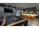 Entertainment space features a pool table, marble countertop bar, and wall-mounted television at 811 Magnum Cliff Ct, Henderson, NV 89012