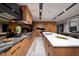 Sleek kitchen featuring wood cabinetry, modern appliances, stone countertops, and a spacious island at 811 Magnum Cliff Ct, Henderson, NV 89012