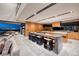 Modern kitchen with sleek wooden cabinets, a large island with seating, and an indoor outdoor dining setup at 811 Magnum Cliff Ct, Henderson, NV 89012