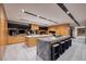 Luxurious kitchen with modern appliances, wood cabinetry, breakfast bar seating, and seamless access to wine cellar at 811 Magnum Cliff Ct, Henderson, NV 89012