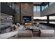 Modern living room with a fireplace, large television, comfortable seating, and seamless indoor-outdoor living at 811 Magnum Cliff Ct, Henderson, NV 89012