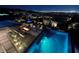 Stunning outdoor pool area with modern seating and city views at night, perfect for relaxing and entertaining at 811 Magnum Cliff Ct, Henderson, NV 89012