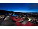 Relaxing pool deck with red lounge chairs and night views of the Las Vegas city lights at 811 Magnum Cliff Ct, Henderson, NV 89012