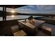 Outdoor patio with a modern table, seating, and an infinity pool overlooking mountain views at 811 Magnum Cliff Ct, Henderson, NV 89012