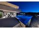 Stunning infinity pool reflecting the home's modern architecture and showcasing city views at night at 811 Magnum Cliff Ct, Henderson, NV 89012
