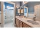 This bathroom features a double sink vanity, blue walls, and white tiling around the bathtub and toilet at 8216 Tursi Lodge Ct, Las Vegas, NV 89131
