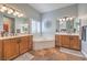 Bathroom with double sinks, a soaking tub, and natural light from the window at 8216 Tursi Lodge Ct, Las Vegas, NV 89131