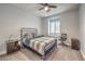 This neutral bedroom features a metal bed frame, ceiling fan, and a window with lots of natural light at 8216 Tursi Lodge Ct, Las Vegas, NV 89131