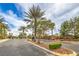 Community entrance featuring lush landscaping, mature trees, and elegant signage, creating an inviting atmosphere at 8216 Tursi Lodge Ct, Las Vegas, NV 89131