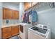 This laundry room features a sink, two white machines, storage cabinets, and a hanging rack for clothes at 8216 Tursi Lodge Ct, Las Vegas, NV 89131