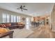 Open-concept living area with a sectional sofa, shutters, and adjacent dining area and kitchen at 8216 Tursi Lodge Ct, Las Vegas, NV 89131