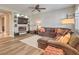 Cozy living room with a fireplace, built-in shelving, large sofa and wood-look flooring at 8216 Tursi Lodge Ct, Las Vegas, NV 89131