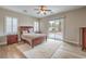 Bright main bedroom featuring hardwood floors, a ceiling fan, plantation shutters, and backyard access at 8216 Tursi Lodge Ct, Las Vegas, NV 89131