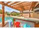 Backyard features a covered outdoor bar with stools, pool, and hammock, ideal for entertaining and relaxation at 8216 Tursi Lodge Ct, Las Vegas, NV 89131