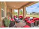 This covered patio includes multiple wicker seats with red cushions and a view of the large backyard at 8216 Tursi Lodge Ct, Las Vegas, NV 89131
