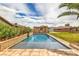 This backyard showcases a long swimming pool with a cabana and plenty of green space at 8216 Tursi Lodge Ct, Las Vegas, NV 89131