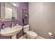 Powder room with purple accent wall, mirror, and pedestal sink at 8216 Tursi Lodge Ct, Las Vegas, NV 89131