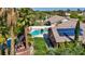 Aerial image of a beautiful backyard oasis with a pool, spa, desert landscaping, and a home with solar panels at 8216 W Hammer Ln, Las Vegas, NV 89149