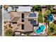Aerial view showcases a home with solar panels, tile roof, covered patio, and backyard pool at 8216 W Hammer Ln, Las Vegas, NV 89149