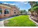 Spacious backyard with a lush green lawn, mature trees, and a beautiful desert landscaped perimeter at 8216 W Hammer Ln, Las Vegas, NV 89149
