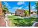 Beautiful backyard featuring well-maintained lawn, mature trees, and appealing landscaping at 8216 W Hammer Ln, Las Vegas, NV 89149