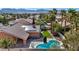 Aerial view of a house with an in-ground pool, solar panels, outdoor kitchen and a well-maintained lawn at 8216 W Hammer Ln, Las Vegas, NV 89149