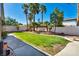 Lush backyard featuring green grass, mature palm trees, and a quaint water feature along the back wall at 8216 W Hammer Ln, Las Vegas, NV 89149
