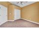 Carpeted bedroom with tan walls featuring a closet with bi-fold doors and standard entry door at 8216 W Hammer Ln, Las Vegas, NV 89149
