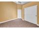 Carpeted bedroom with tan walls featuring a closet with bi-fold doors and a standard entry door at 8216 W Hammer Ln, Las Vegas, NV 89149