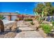 Charming home featuring a stone pathway with solar lighting and desert landscaping at 8216 W Hammer Ln, Las Vegas, NV 89149
